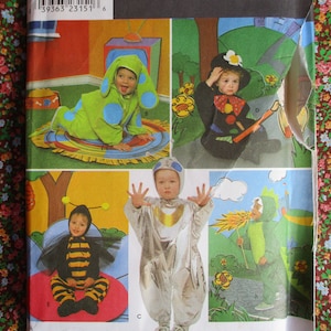 May include: A sewing pattern featuring five different children's costumes. The costumes include a bee, a blue character, a space explorer, a clown, and a dragon. The pattern includes instructions and diagrams for sewing each costume.