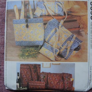 May include: A sewing pattern envelope labeled 3693 featuring illustrations of quilted bags in two colorways. The top image shows yellow and blue floral patterned tote bags and pouches. The bottom image displays the same bag styles in red and brown.