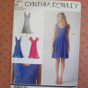May include: A Cynthia Rowley sewing pattern package featuring dress designs. The package includes a photo of a woman wearing a blue dress, along with illustrations of other dress styles in blue, pink, and a floral print.