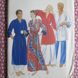 May include: A sewing pattern illustration featuring four figures wearing robes and loungewear. One figure wears a long blue robe, another a long red patterned robe, a third a red robe with white pants, and the fourth a white robe with blue pants.