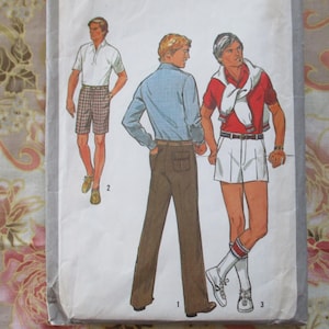 May include: A sewing pattern for three different men's outfits. The first outfit is a blue button-down shirt with brown pants. The second outfit is a white polo shirt with brown shorts. The third outfit is a red polo shirt with white shorts.