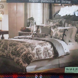 May include: A bed with a comforter and pillows. The comforter has a toile pattern in shades of brown and white. The pillows have a mix of patterns, including gingham and stripes. The bed skirt has a striped pattern.
