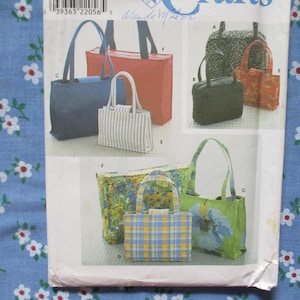May include: A sewing pattern sheet featuring various tote bag designs. The bags are shown in different colors and patterns, including solid colors, stripes, floral prints, and plaid. The bags have different handle styles and sizes.