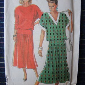 Puede incluir: Dos patrones de vestidos para mujeres. El patrón de la izquierda es un vestido rojo con una falda que llega a la rodilla. El patrón de la derecha es un vestido verde con una falda que llega a la rodilla. Ambos patrones tienen un ribete blanco alrededor del cuello.