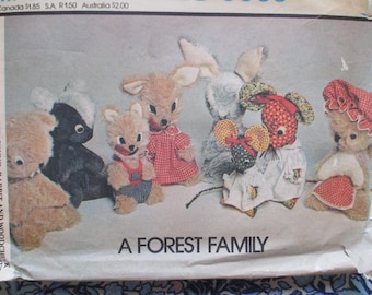 Könnte beinhalten: Ein Vintage-Schnittmuster mit Designs für Stofftiere. Das Muster enthält Anleitungen für einen Wolf, ein Eichhörnchen, eine Maus, ein Stinktier und ein Kaninchen. Die Tiere sind in verschiedenen Outfits abgebildet, mit dem Text "A FOREST FAMILY" unten.