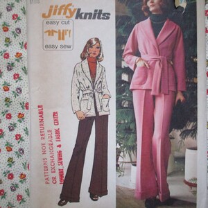 Könnte beinhalten: Ein Vintage-Schnittmuster für ein zweiteiliges Outfit. Das Schnittmuster zeigt eine langärmelige Jacke mit Bindegürtel und eine weite Hose. Das Schnittmuster ist mit "Jiffyknits" beschriftet und trägt die Aufschrift "einfach zu schneiden" und "einfach zu nähen".