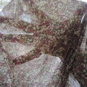May include: A sheer fabric with a floral pattern in shades of brown, pink, and white.