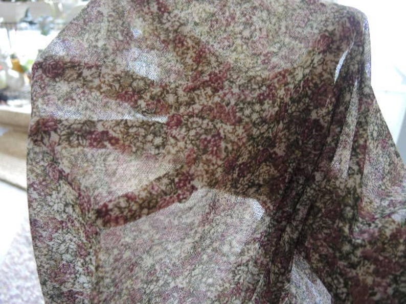 May include: A sheer fabric with a floral pattern in shades of brown, pink, and white.
