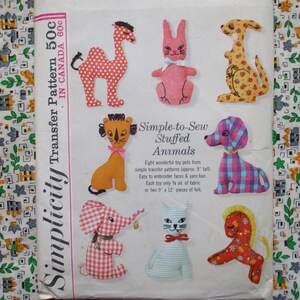 May include: A vintage Simplicity transfer pattern featuring simple-to-sew stuffed animals. The pattern includes designs for a camel, rabbit, kangaroo, lion, dog, elephant, cat, and horse. Each toy is approximately 9 inches tall and made from fabric and yarn.