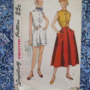 May include: Vintage Simplicity printed sewing pattern featuring two women's outfits. One outfit is a white shorts set with a collared shirt, and the other is a yellow top with a red skirt. The pattern is on a floral background.