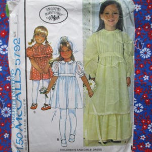 May include: Vintage McCall's pattern for children's and girls' dresses. The pattern features illustrations of three different dress styles, including a long yellow dress and two shorter dresses. The pattern is size 6.