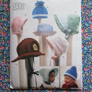 May include: A sewing pattern for making baby bonnets. The pattern includes six different styles of bonnets, including a fireman's hat, a sun hat, and a bonnet with a ruffle. The pattern is designed by Linda Carr.