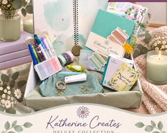 May include: A stationery gift box containing a spiral-bound notebook, a teal journal with a Katherine Creates label, a clear pouch of colorful pens, sticky notes, a small pouch, paper clips, and a card with the text My potential is limitless.