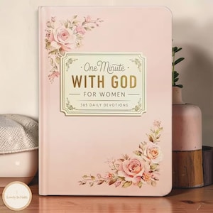 May include: A light pink hardcover book titled One Minute WITH GOD FOR WOMEN 365 DAILY DEVOTIONS. The cover features floral illustrations of roses in the top left and bottom right corners, with gold lettering centered on a cream-colored label.