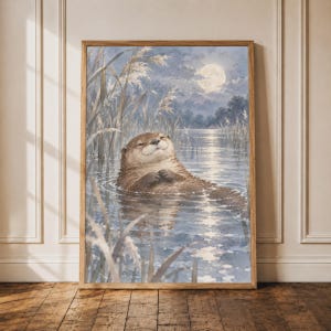 Könnte beinhalten: Ein gerahmter Kunstdruck mit einer Aquarellillustration eines braunen Otters, der nachts in einem ruhigen Fluss schwimmt. Die Szene zeigt hohe Schilfhalme im Vordergrund, einen Vollmond am bewölkten Himmel und das Mondlicht auf der Wasseroberfläche.