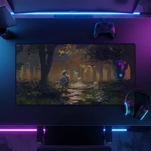 May include: A rectangular desk mat featuring a printed illustration of a character with a shield standing in a dark forest clearing with a glowing blue fairy, positioned on a dark desk with a game controller, a computer mouse, and headphones.