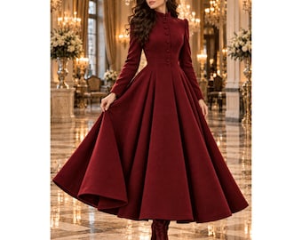 May include: A floor-length, deep burgundy coat featuring a high collar, long sleeves, and a row of matching buttons down the front. The garment has a fitted bodice and a full, pleated skirt that flares out from the waist, creating a structured silhouette.
