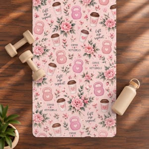 May include: A rectangular yoga mat with a light pink background featuring a repeating pattern of pink kettlebells, coffee cups with heart icons, and floral bouquets. The text "lift sip repeat" and "COFFEE N KETTLEBELLS" is printed throughout.