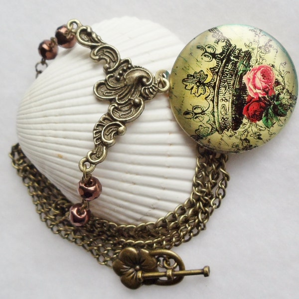 Round locket with crown and roses on front cover adorned with copper color beads and bronze accents