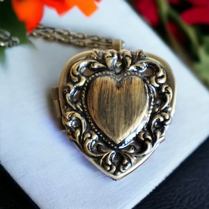 Music box locket, heart locket with music box inside, in bronze with lacey edge floral heart on cover.