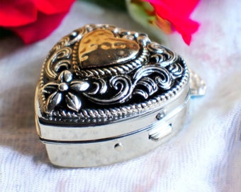 Music box locket,  heart shaped locket with music box inside, in silver tone with heart on front cover.