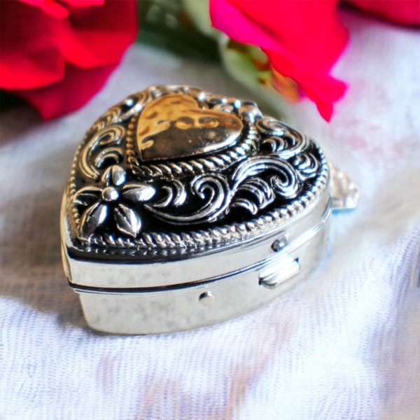 Music box locket,  heart shaped locket with music box inside, in silver tone with heart on front cover.