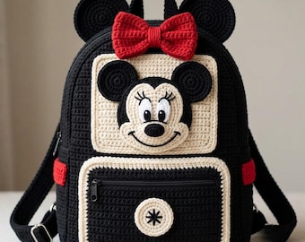 May include: A black crochet backpack featuring a cream-colored square panel with a Minnie Mouse face appliqué. The bag includes a bright red crochet bow at the top, two round black ears, and a front zippered pocket with a circular cream accent.