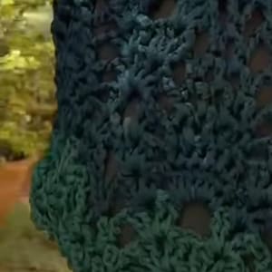 Peut inclure: Un sac à main en crochet vert foncé présentant un motif ajouré et une anse incurvée en bambou marron clair. Le sac est fabriqué à partir de fil épais, créant un aspect texturé en forme de filet avec des espaces visibles sur tout le corps.