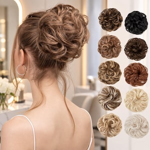 May include: A messy hair bun hairpiece with wavy, textured strands. The main image shows a light brown bun worn in a high updo. To the right, a vertical column displays ten variations of the hair bun in different shades, including black, brown, blonde, and highlighted tones.