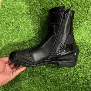 Puede incluir: Una bota de motocicleta negra con cierre de cremallera lateral, puntera reforzada con detalles texturizados, secci&oacute;n de tobillo acolchada y protector de tal&oacute;n r&iacute;gido. La bota est&aacute; fabricada con materiales sint&eacute;ticos lisos y texturizados.