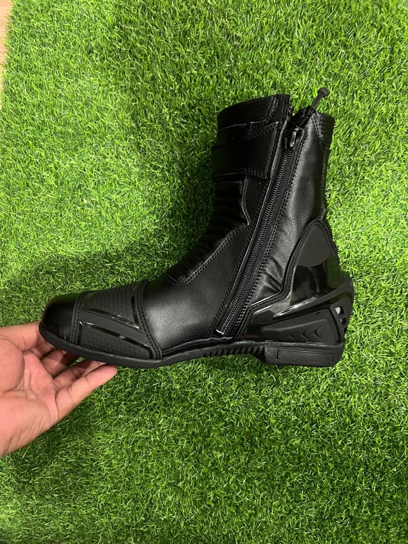 Puede incluir: Una bota de motocicleta negra con cierre de cremallera lateral, puntera reforzada con detalles texturizados, secci&oacute;n de tobillo acolchada y protector de tal&oacute;n r&iacute;gido. La bota est&aacute; fabricada con materiales sint&eacute;ticos lisos y texturizados.