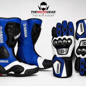 Puede incluir: Un par de botas de moto azules, blancas y negras junto a un par de guantes de moto a juego. Las botas y los guantes presentan el logotipo de Yamaha y el texto THEMOTOGEAR. El equipo cuenta con acolchado protector y paneles reforzados.