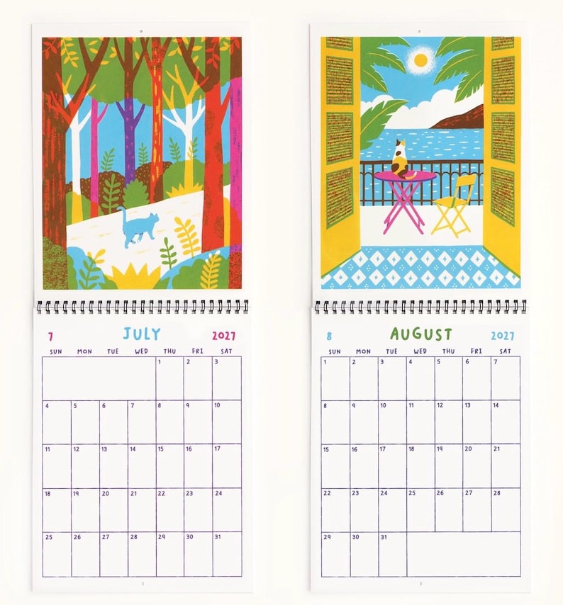 May include: A 2027 wall calendar featuring two open pages for July and August. July displays a colorful forest illustration with a blue cat. August shows a balcony view with a cat, a pink table, and a yellow chair overlooking the sea.
