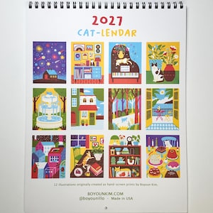 May include: A 2027 wall calendar titled CAT-LENDAR featuring twelve colorful illustrations of cats in various settings. The calendar includes text stating 12 illustrations originally created as hand-screen prints by Boyoun Kim, BOYOUNKIM.COM, @boyounillo, and Made in USA.