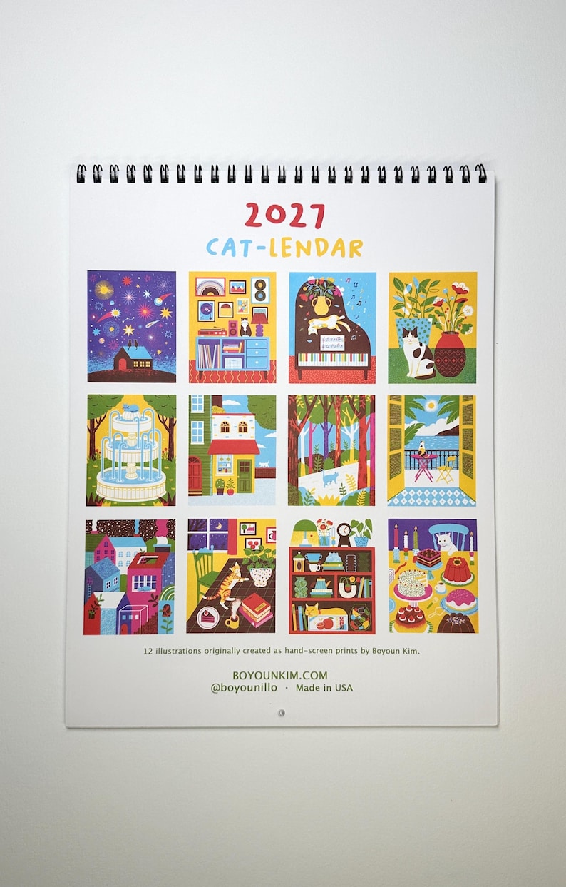 May include: A 2027 wall calendar titled CAT-LENDAR featuring twelve colorful illustrations of cats in various settings. The calendar includes text stating 12 illustrations originally created as hand-screen prints by Boyoun Kim, BOYOUNKIM.COM, @boyounillo, and Made in USA.