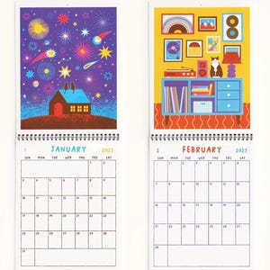 May include: A 2027 wall calendar showing January and February pages. January features a house under a starry purple sky with two cats on the roof. February displays a yellow room with a blue cabinet, a record player, and a cat. Each page includes a grid.