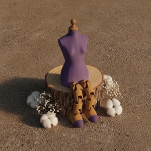May include: A purple mannequin torso with a wooden neck cap and articulated wooden legs with purple-tipped feet, seated on a circular wooden log slice, surrounded by small white cotton bolls and sprigs of dried baby's breath flowers.