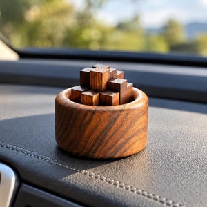 May include: A dark brown wooden puzzle consisting of multiple interlocking cubic blocks nested within a circular wooden bowl. The wood features a visible natural grain pattern throughout the surface of both the bowl and the individual puzzle pieces.