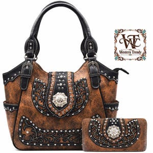 May include: A brown distressed handbag and matching wallet set featuring black trim, silver-tone metal studs, and a central silver floral concho ornament. The handbag has two black handles with buckles and side pockets. The logo Western Trendy is visible.