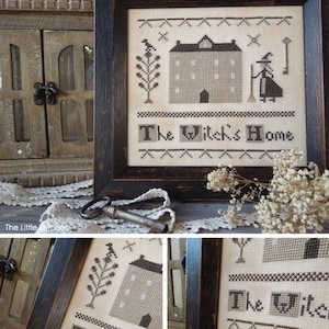 Könnte beinhalten: Eine gerahmte Kreuzstich-Stickerei, die ein Haus mit einer Hexe davor zeigt. Der Text "The Witch's Home" ist unter dem Haus gestickt. Die Stickerei ist in einem dunklen Holzrahmen mit einer abgenutzten Oberfläche gerahmt.