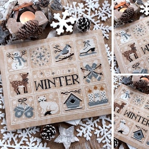 Peut inclure: Une broderie au point de croix sur le thème de l'hiver. Le motif présente des carrés avec des images d'un bonhomme de neige, d'un cerf, d'un oiseau, d'un patin à glace et d'un chat. Les mots "Welcome Winter" sont brodés au centre. La palette de couleurs comprend le beige, le blanc et le marron.