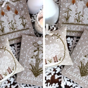May include: Hand-stitched Christmas ornaments and pillows. The ornaments feature candle and floral designs, with the word "CANDLEMAS" embroidered on one. The pillows have a sheep design and floral designs. All are on a beige background with white polka dots.