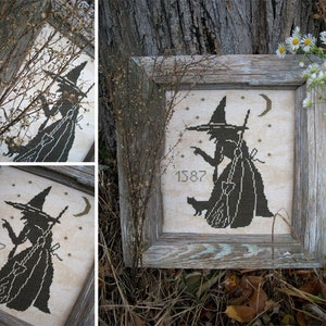 Könnte beinhalten: Ein gerahmtes Kreuzstich-Design einer Hexe mit einer schwarzen Katze und einem Besen, mit dem Jahr 1587 in der linken unteren Ecke gestickt. Das Design ist auf einem cremefarbenen Stoff mit einem braunen Holzrahmen.