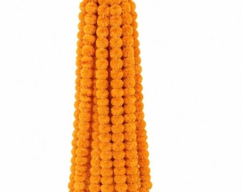 May include: A vertical hanging decoration consisting of multiple strands of bright orange marigold flowers. The flowers are densely packed in a cylindrical arrangement, suspended from a central point by thin white strings at the top.