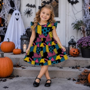 May include: A sleeveless dress featuring a patchwork pattern of yellow, teal, pink, and black geometric shapes with polka dots and stripes. The dress has a round neckline and ruffled cap sleeves, constructed with a fitted bodice and a flared skirt.