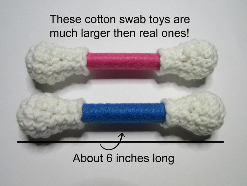 May include: Two crocheted cotton swab toys, one with a pink and one with a blue center, are about 6 inches long. These are much larger than real cotton swabs.
