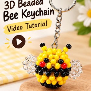 May include: A 3D beaded bee keyring featuring yellow, black, and red beads with clear wings, attached to a silver metal ring. The image includes the text 3D Beaded Bee Keychain Video Tutorial with a play button icon and a small bee illustration.