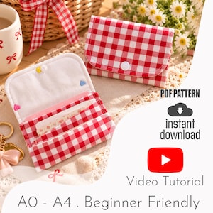 May include: A red and white gingham fabric wallet featuring a snap button closure. The interior includes card slots and a white lining with small embroidered hearts. The text reads: PDF PATTERN, instant download, Video Tutorial, A0 - A4 . Beginner Friendly.