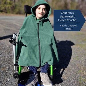 May include: A dark green fleece poncho with a hood and a full-length front zipper. The text on the image reads: Children's Lightweight Fleece Poncho. Fabric Choices Inside! The poncho is worn over dark blue pants and grey sneakers while seated.