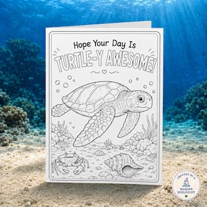 May include: A white greeting card featuring a black and white line art illustration of a sea turtle swimming above a crab and a seashell on the ocean floor. The text at the top reads Hope Your Day Is TURTLE-Y AWESOME! with a small heart icon.